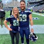 Ashley and Tyler Ott stand together on the field in a football stadium, both wearing jerseys with the number 69