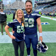Ashley and Tyler Ott stand together on the field in a football stadium, both wearing jerseys with the number 69